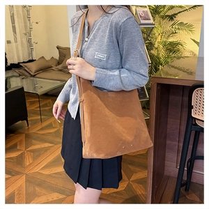 Close-up of brown suede shoulder bag with fine matte texture and large capacity