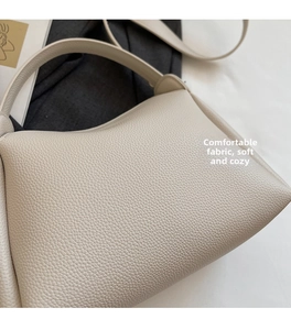 Gros plan du sac seau blanc crème montrant la texture litchi douce et les coutures fines