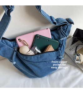 Blue denim crossbody bag with large capacity, front zip pocket, and storage space
