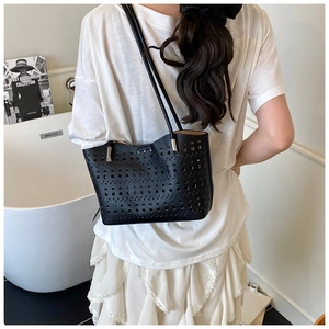 Primer plano del bolso tote negro con delicado diseño geométrico calado y corte por láser