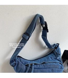 Detail view of blue denim crescent bag with adjustable strap and buckle design