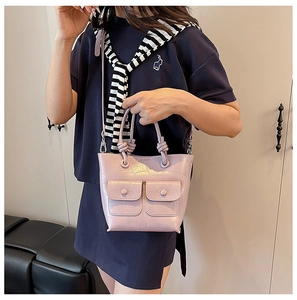 Detail of light purple crocodile pattern leather handbag with knotted handles