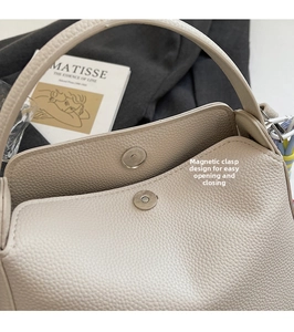 Détail du fermoir magnétique d'un sac seau beige avec texture cuir de litchi