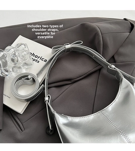 Silver crescent shoulder bag with metallic finish and decorative bow strap detail
