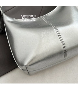 Detailed macro view of the silver metallic cracked leather texture and reinforced double stitching
