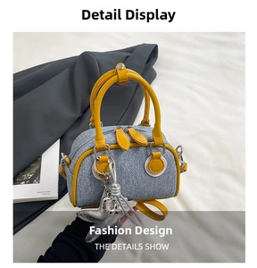 Detail of denim underarm bag with yellow leather trim and silver star charm