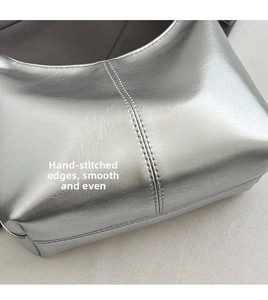 Close-up of silver leather handbag showing detailed stitching and premium metallic texture