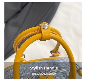 Detail of light blue denim handbag with yellow leather handles and silver snap fastener