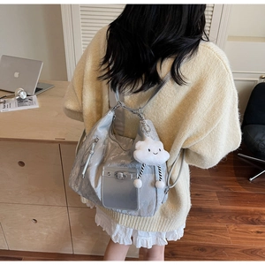 Detail of silver metallic backpack with fluffy white cloud charm and glossy finish