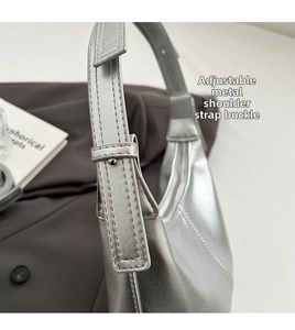 Detail of silver bucket bag showing the adjustable shoulder strap and metal buckle pin
