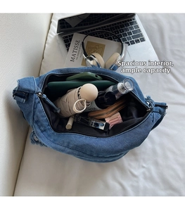 Spacious interior of blue denim dumpling bag showing storage for umbrella and wallet