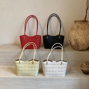 Bolsos tote calados en cuatro colores sobre escalones de piedra para un estilo minimal