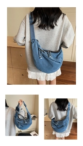 Detail of blue denim crescent crossbody bag with adjustable wide strap and knotted zipper