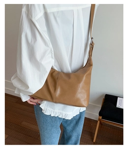 Détail d'un grand sac bandoulière vintage en cuir souple marron avec large sangle