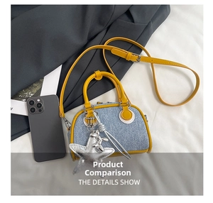Detail of denim blue crossbody bag with yellow leather trim and silver star charm accessory