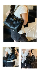 Detail of black quilted leather tote bag with gold chain strap and secure metal turn-lock