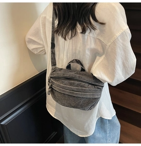 Sac bandoulière en denim délavé gris porté par un mannequin en extérieur