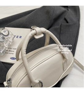 Detail of off-white bowling handbag with smooth leather texture and sturdy handles