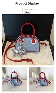 Detail of blue denim mini bag with red leather handles and silver star charm