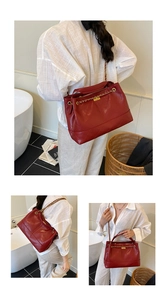 Detail view of large red quilted leather tote with gold chain strap and secure metal lock