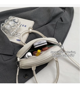 Interior view showing spacious storage capacity for cosmetics in the off-white bowling bag