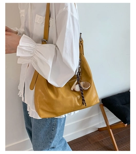 Gros plan d'un sac fourre-tout jaune gingembre avec pendentif sport et boucle argentée