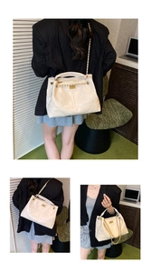 Detail of quilted texture, gold chain strap and metal lock on off-white handbag