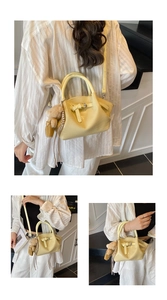 Detail of yellow crocodile embossed handbag with bow buckle and cute plush bear charm