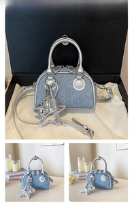 Detail of blue denim mini Boston bag with silver metallic handle and star pendant