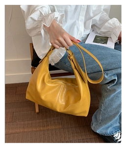 Yellow leather crescent hobo bag with pleated detail and adjustable shoulder strap