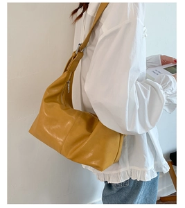 Vue détaillée du grand sac hobo jaune avec texture cuir plissé et large bandoulière