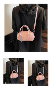 Detail of a pink vintage bowling handbag with adjustable shoulder strap and silver key charm