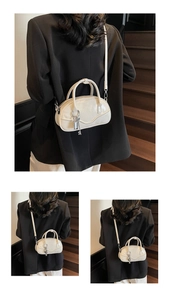 Close-up of a white glossy PU bowling bag with round handles and a silver lock charm