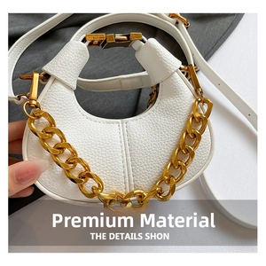 Close-up of white lychee leather crescent bag with chunky gold chain detail