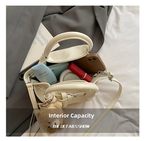 Internal view of a white crocodile pattern handbag showing space for makeup and phone