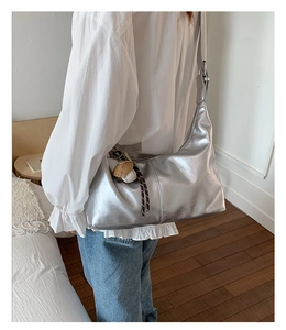 Détail du grand sac cabas argenté métallisé avec pendentif ours et balle de baseball