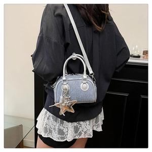 Detail of blue denim mini Boston bag with silver leather handles and star charm