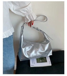 Close-up of a metallic silver hobo bag featuring pleated faux leather and adjustable strap