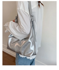 Side view of metallic silver hobo bag showing large capacity and soft texture on model