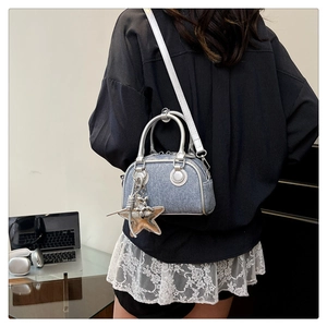 Detail of blue denim mini handbag featuring silver leather trim and cute star pendant