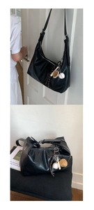 Close-up of black retro hobo bag with unique baseball glove and bat themed keychains