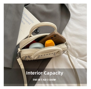 Detail view of compact rivet crossbody bag showing internal capacity for daily essentials