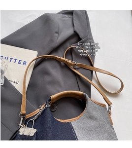 Detail of canvas bucket bag with metal chain, padlock deco, and adjustable strap