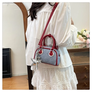 Blue denim bowling bag with red leather handles and large silver star charm details