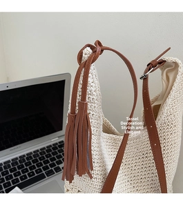 Detail of hollow knit tote bag featuring brown leather fringe and a sturdy woven texture