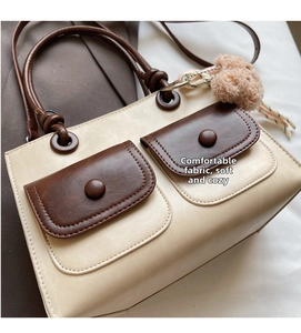 Detailed close-up of a cream and brown PU leather tote bag with soft texture and pockets