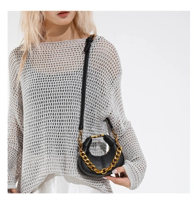 Détail du sac croissant en cuir noir avec chaîne dorée et fine bandoulière réglable