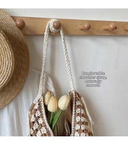 Close-up of brown and white checkered woven tote bag with thick strap and tassel details