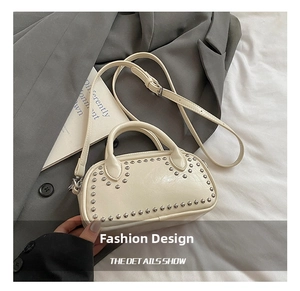 Detail shot of the cream mini bowling bag featuring silver rivets and glossy finish