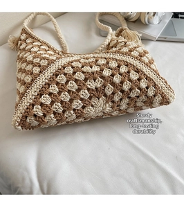 Detail of hand-woven crochet tote bag with checkerboard pattern and tassel charm